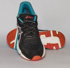 black ASICS GEL-Rush33 running shoe featuring teal interior lining and a white midsole with orange and blue outsole accents.