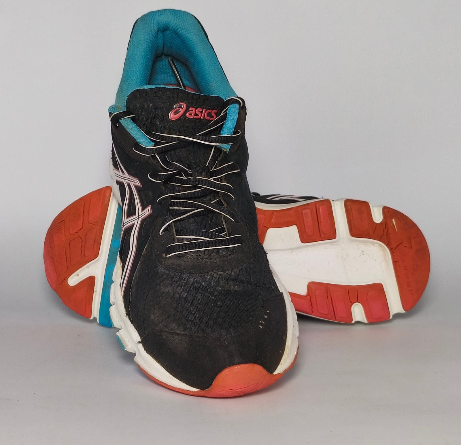 black ASICS GEL-Rush33 running shoe featuring teal interior lining and a white midsole with orange and blue outsole accents.