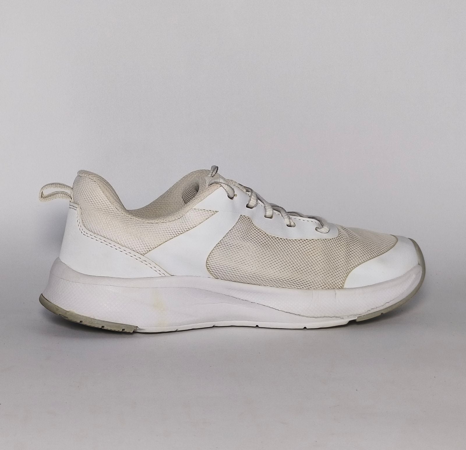 white and light grey athletic running shoe featuring silver accents and a thick white cushioned midsole.