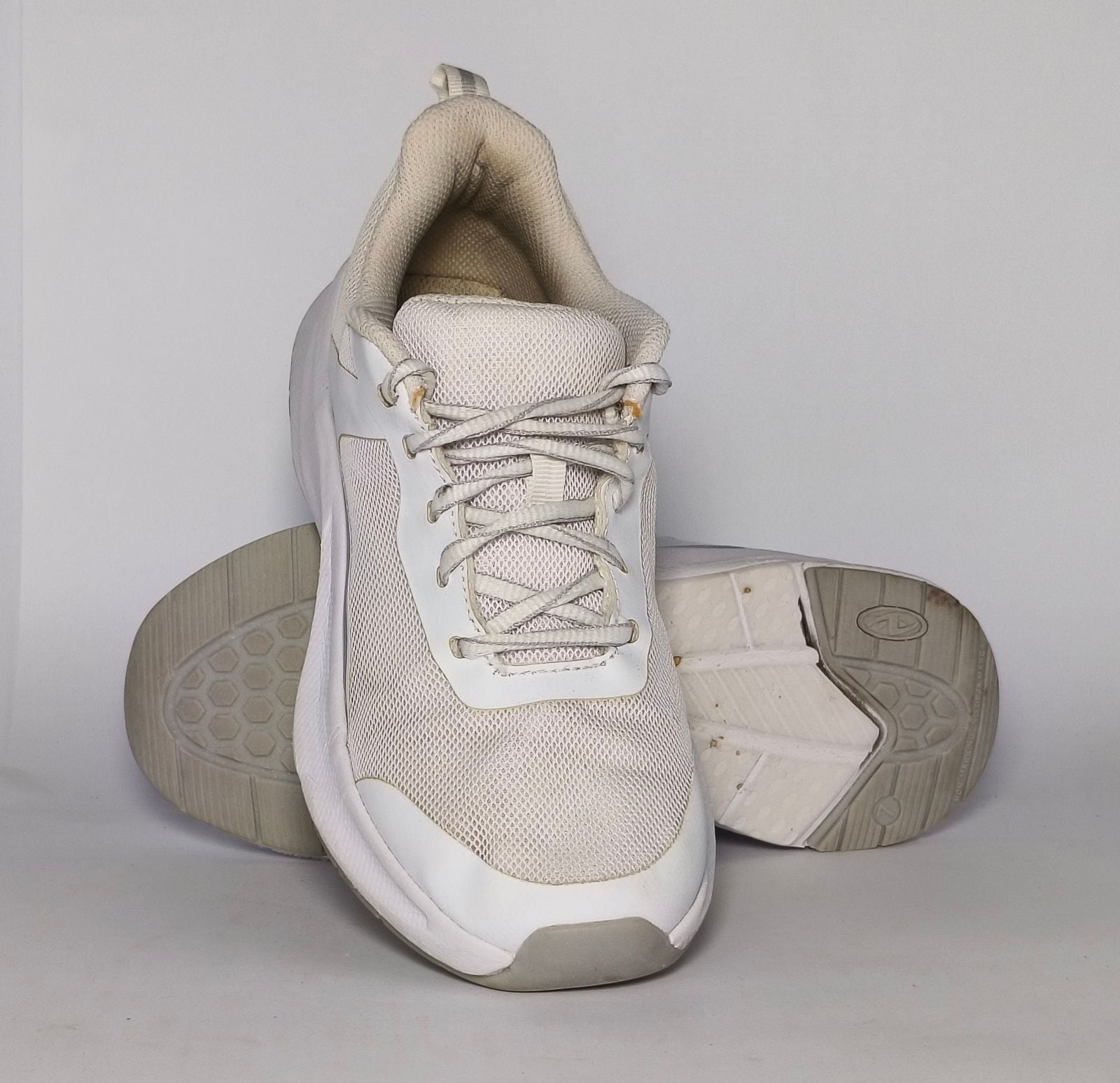 white and light grey athletic running shoe featuring silver accents and a thick white cushioned midsole.