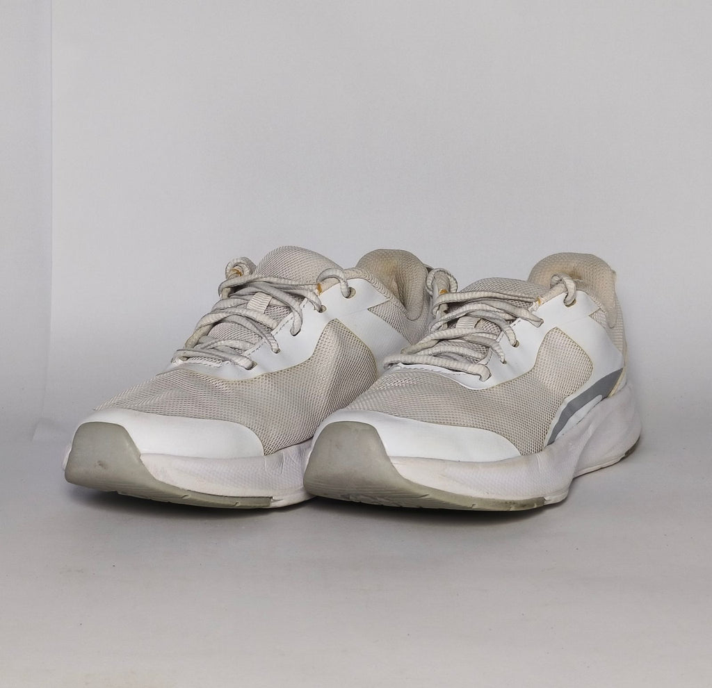 white and light grey athletic running shoe featuring silver accents and a thick white cushioned midsole.