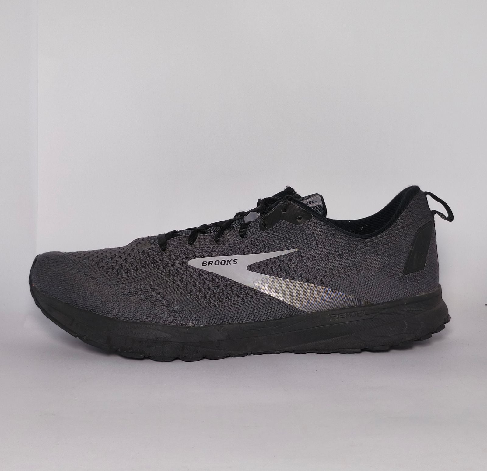 charcoal grey Brooks Revel running shoe featuring a silver logo and a black cushioned midsole.
