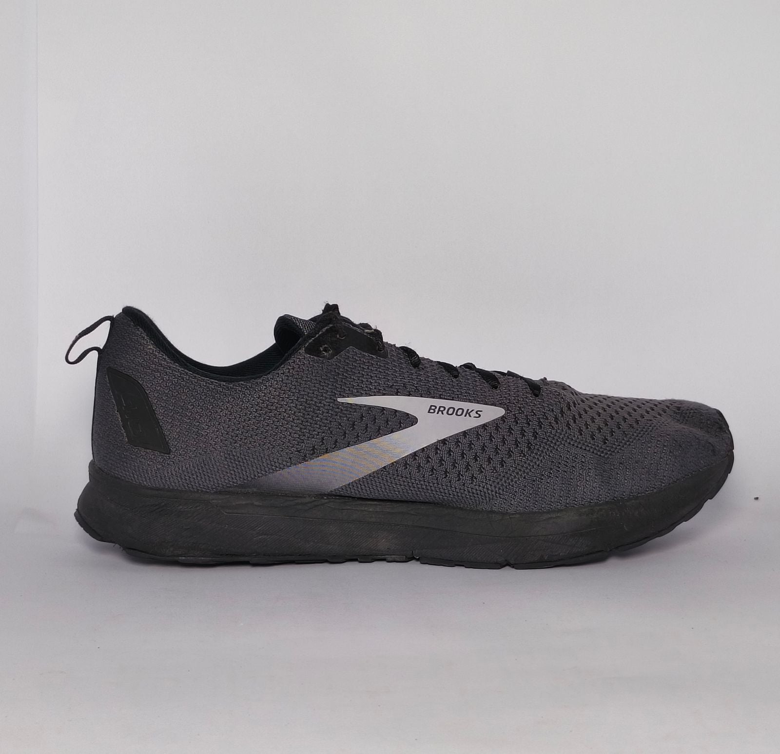 charcoal grey Brooks Revel running shoe featuring a silver logo and a black cushioned midsole.