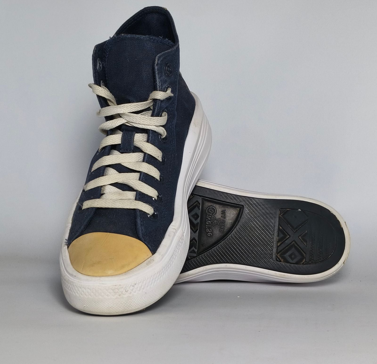 navy blue Converse Move platform high-top sneaker featuring a thick white midsole and a gold toe cap.