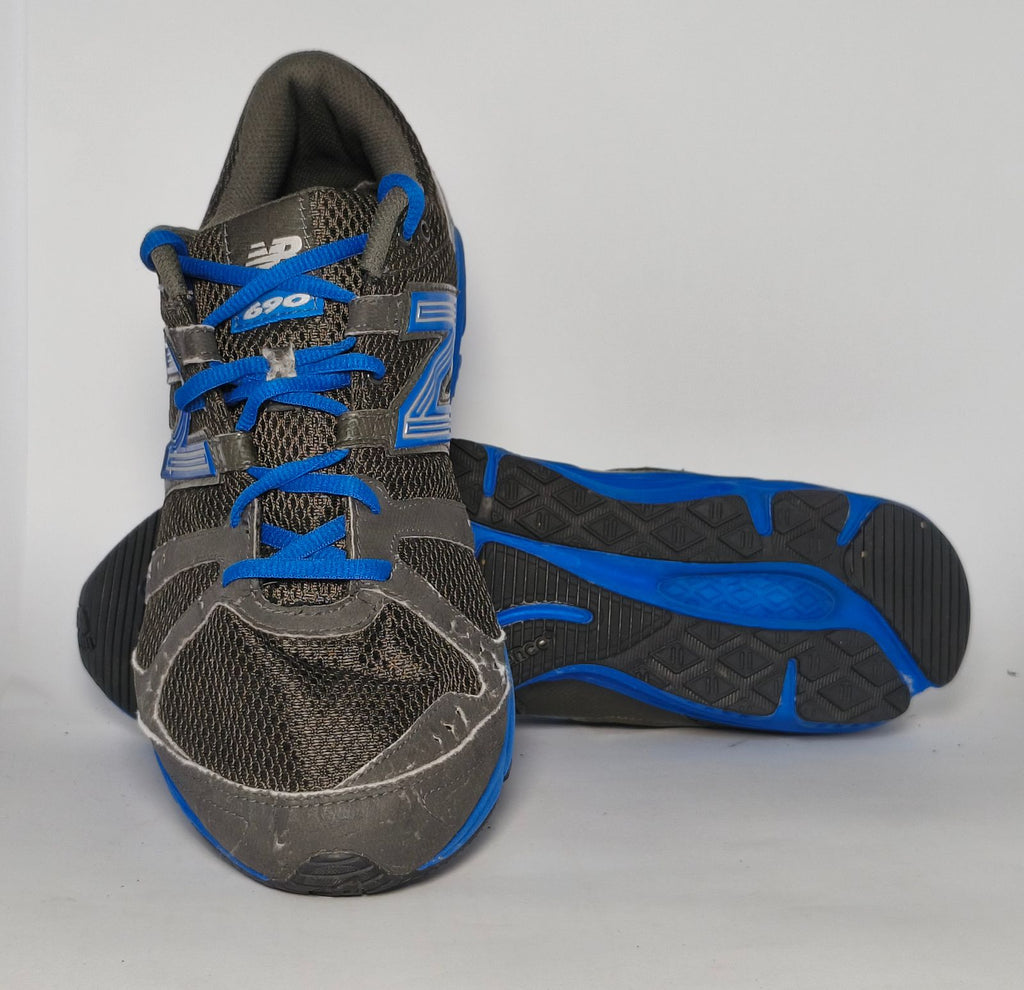 charcoal grey and black New Balance running shoe featuring royal blue laces, logo, and midsole.