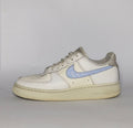 white Nike Air Force 1 Low sneaker featuring a light blue patterned Swoosh and a vintage sail-colored midsole.
