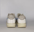 white Nike Air Force 1 Low sneaker featuring a light blue patterned Swoosh and a vintage sail-colored midsole.