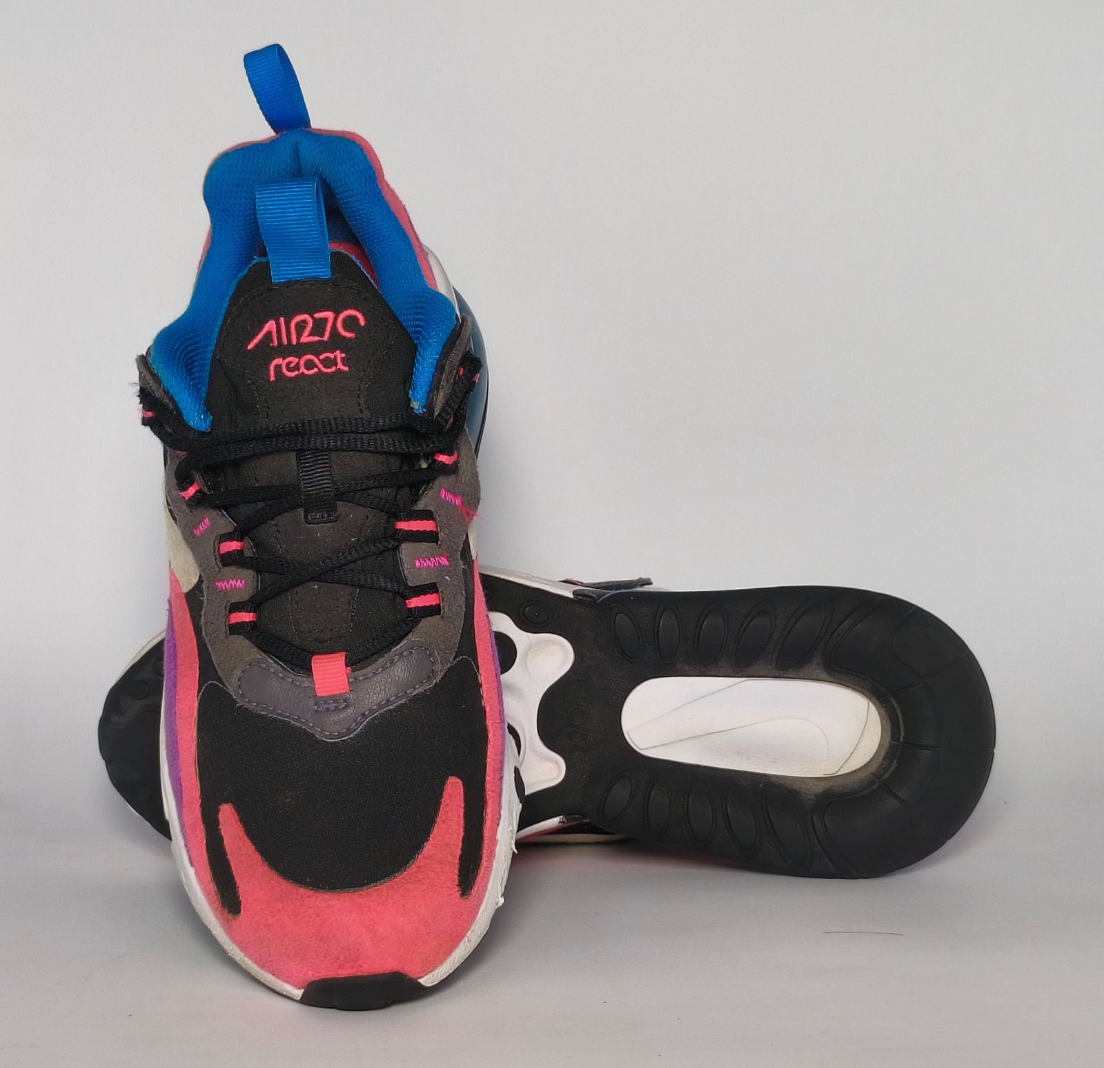 Nike Air Max 270 React sneaker featuring a pink and purple upper, a white React midsole, and a blue tinted Max Air heel unit.