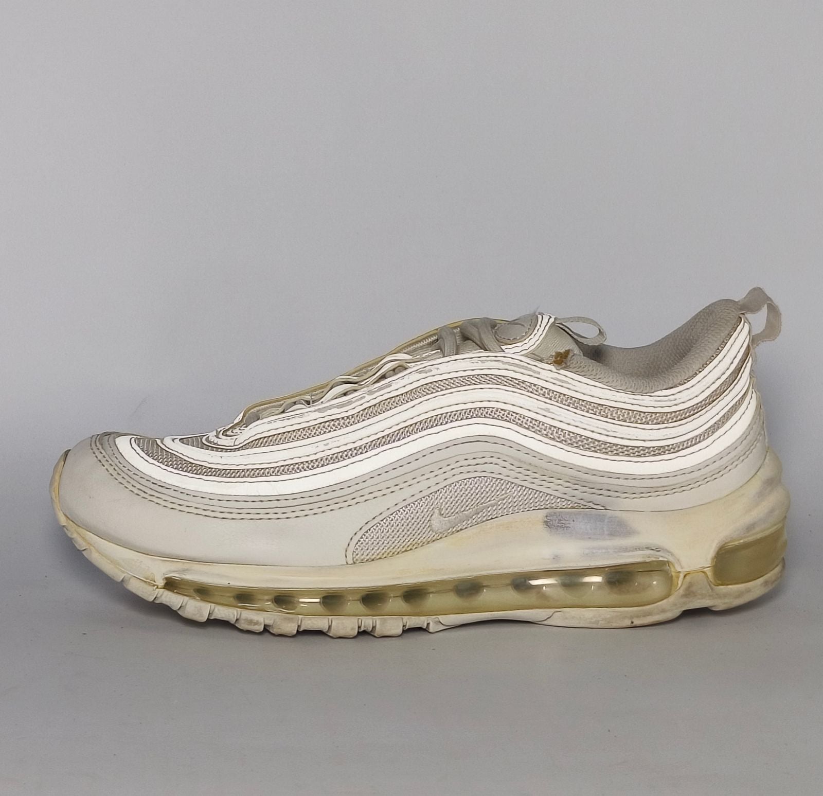 light grey and cream Nike Air Max 97 sneaker featuring the iconic ripple design and a full-length visible Max Air cushioning unit.