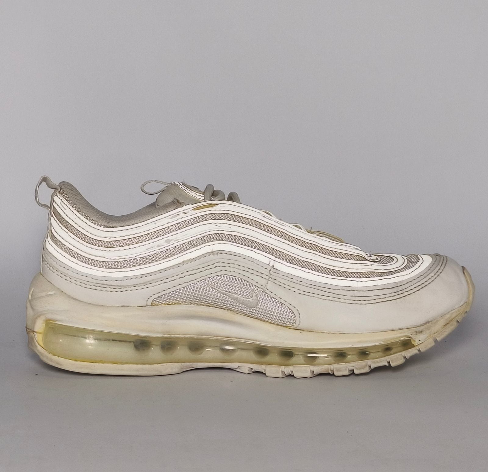 light grey and cream Nike Air Max 97 sneaker featuring the iconic ripple design and a full-length visible Max Air cushioning unit.