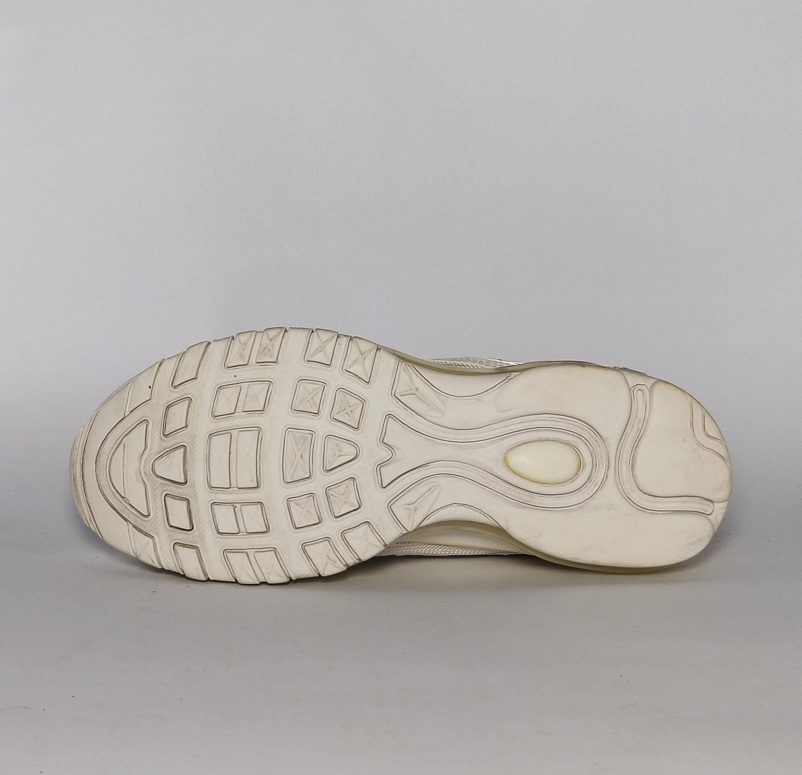 light grey and cream Nike Air Max 97 sneaker featuring the iconic ripple design and a full-length visible Max Air cushioning unit.
