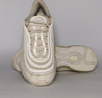light grey and cream Nike Air Max 97 sneaker featuring the iconic ripple design and a full-length visible Max Air cushioning unit.