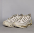light grey and cream Nike Air Max 97 sneaker featuring the iconic ripple design and a full-length visible Max Air cushioning unit.