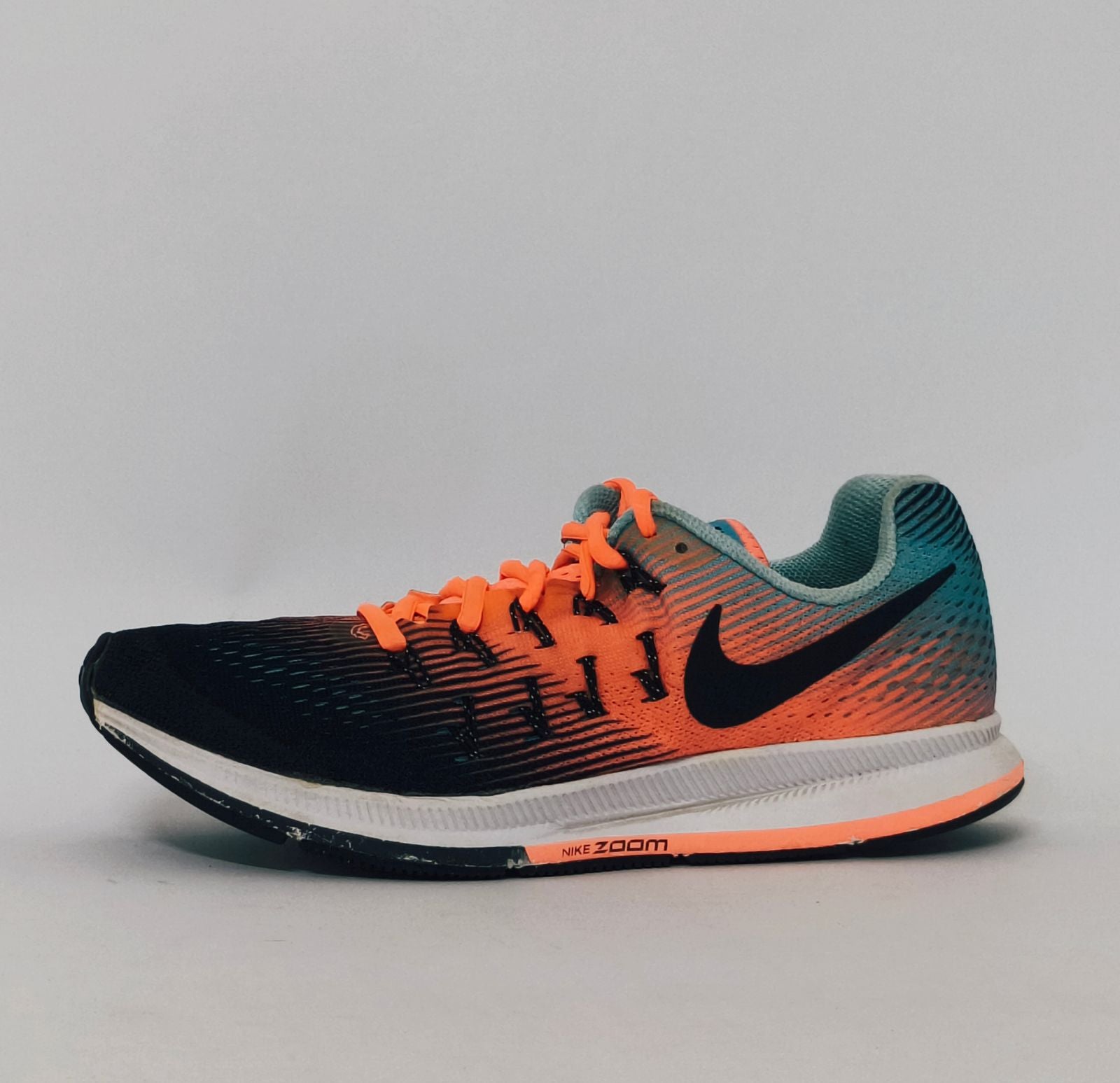 Nike Air Zoom Pegasus 33 running shoe featuring an orange and blue gradient mesh upper and a white Nike Zoom midsole.