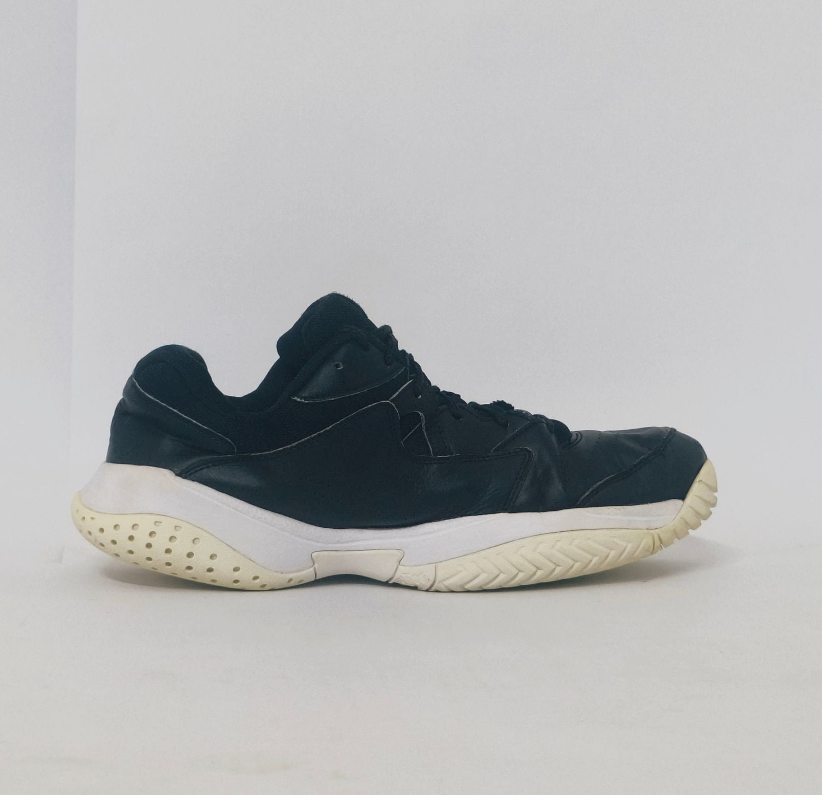 black Nike court sneaker featuring a white Swoosh and a thick white midsole with court-ready traction.