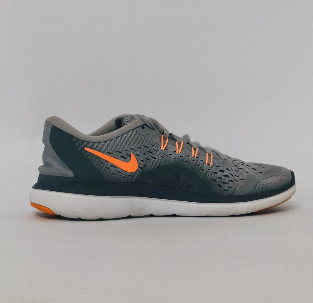 grey Nike Flex 2017 RN running shoe featuring an orange Swoosh and a flexible white midsole.