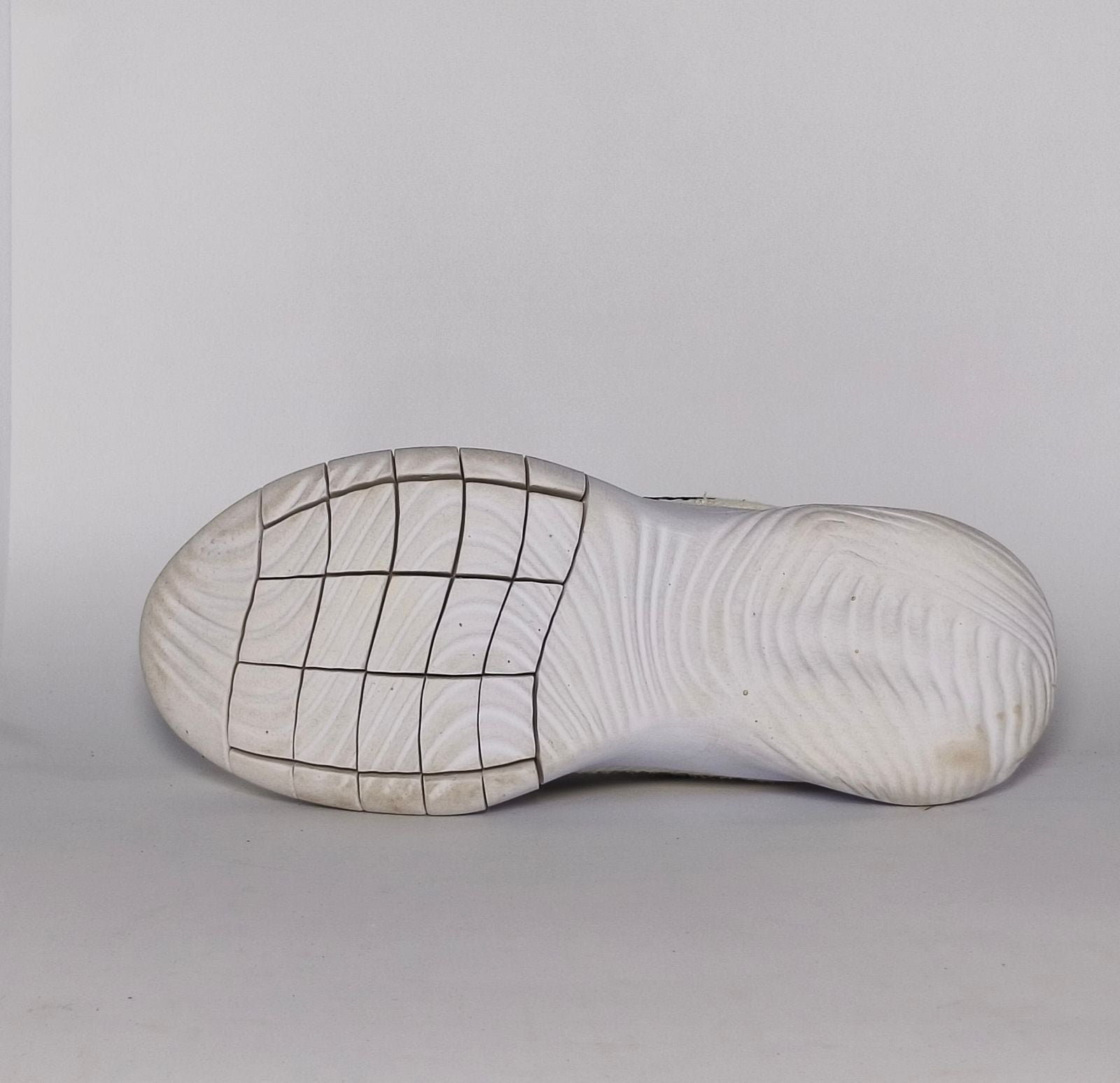 cream-colored Nike Flex Experience running shoe featuring a purple ankle collar, a black Swoosh, and a white flexible midsole.