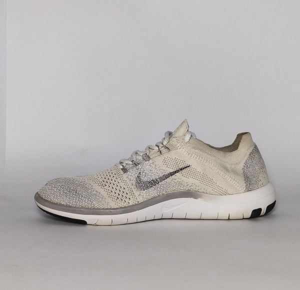 cream and grey Nike Free RN Flyknit running shoe featuring a white flexible midsole and a minimalist textured design.