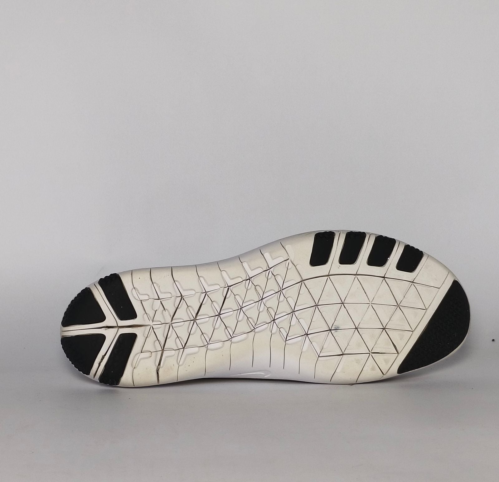 cream and grey Nike Free RN Flyknit running shoe featuring a white flexible midsole and a minimalist textured design.