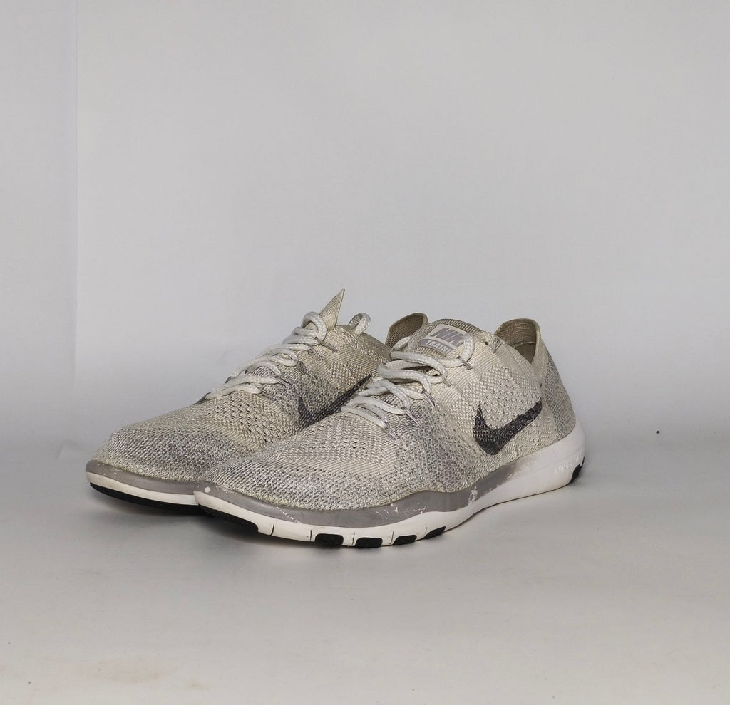 cream and grey Nike Free RN Flyknit running shoe featuring a white flexible midsole and a minimalist textured design.