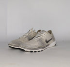 cream and grey Nike Free RN Flyknit running shoe featuring a white flexible midsole and a minimalist textured design.