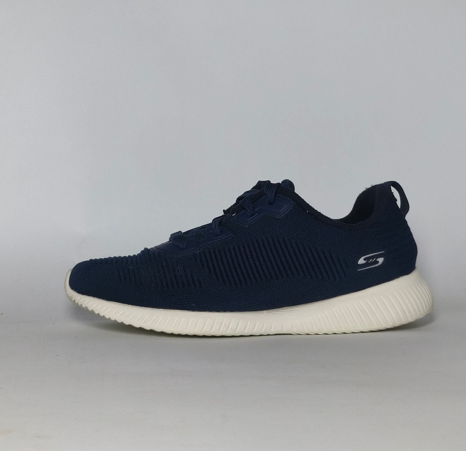 navy blue Skechers BOBS Squad sneaker featuring a white midsole and a textured knit upper.