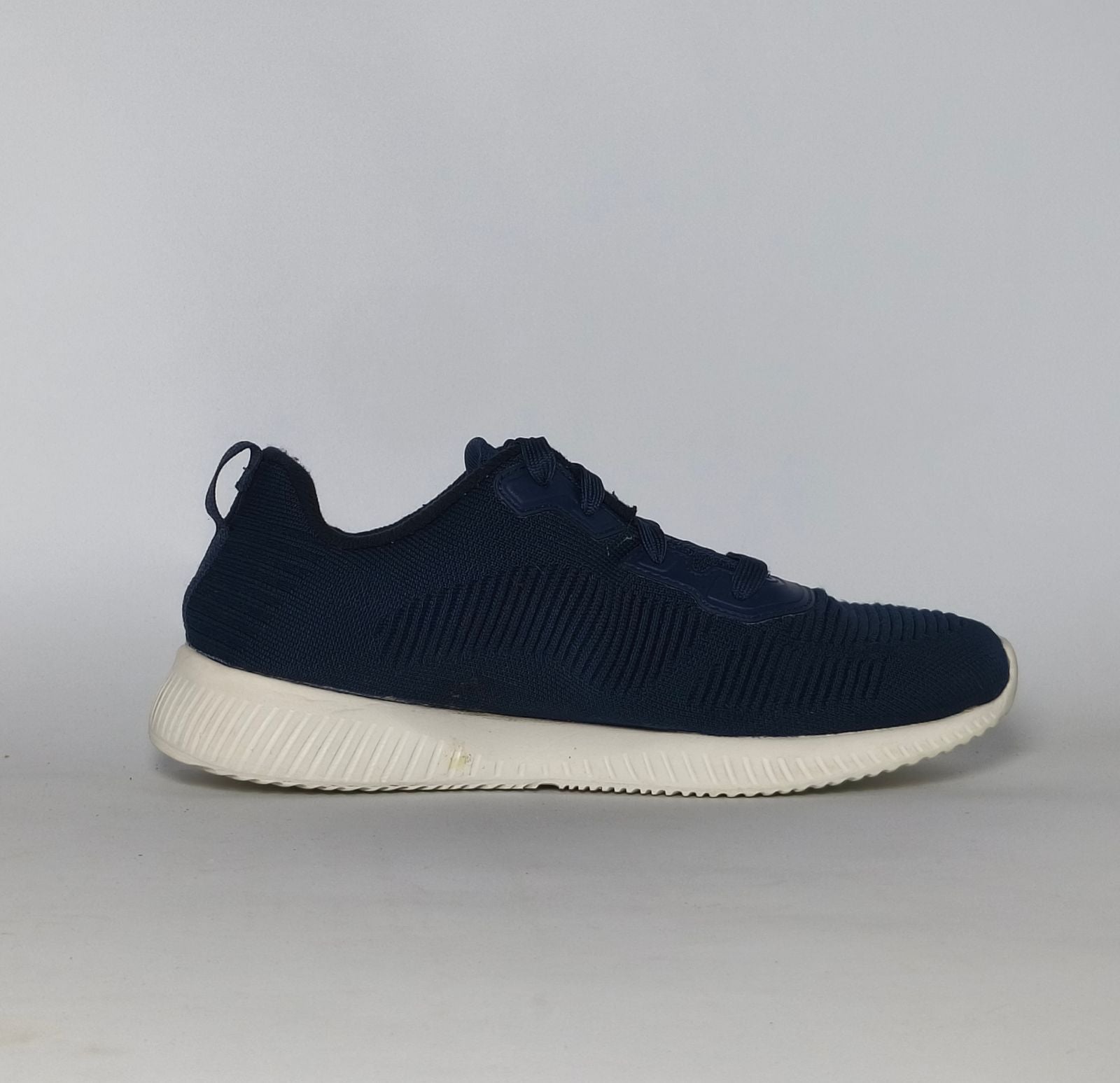 navy blue Skechers BOBS Squad sneaker featuring a white midsole and a textured knit upper.