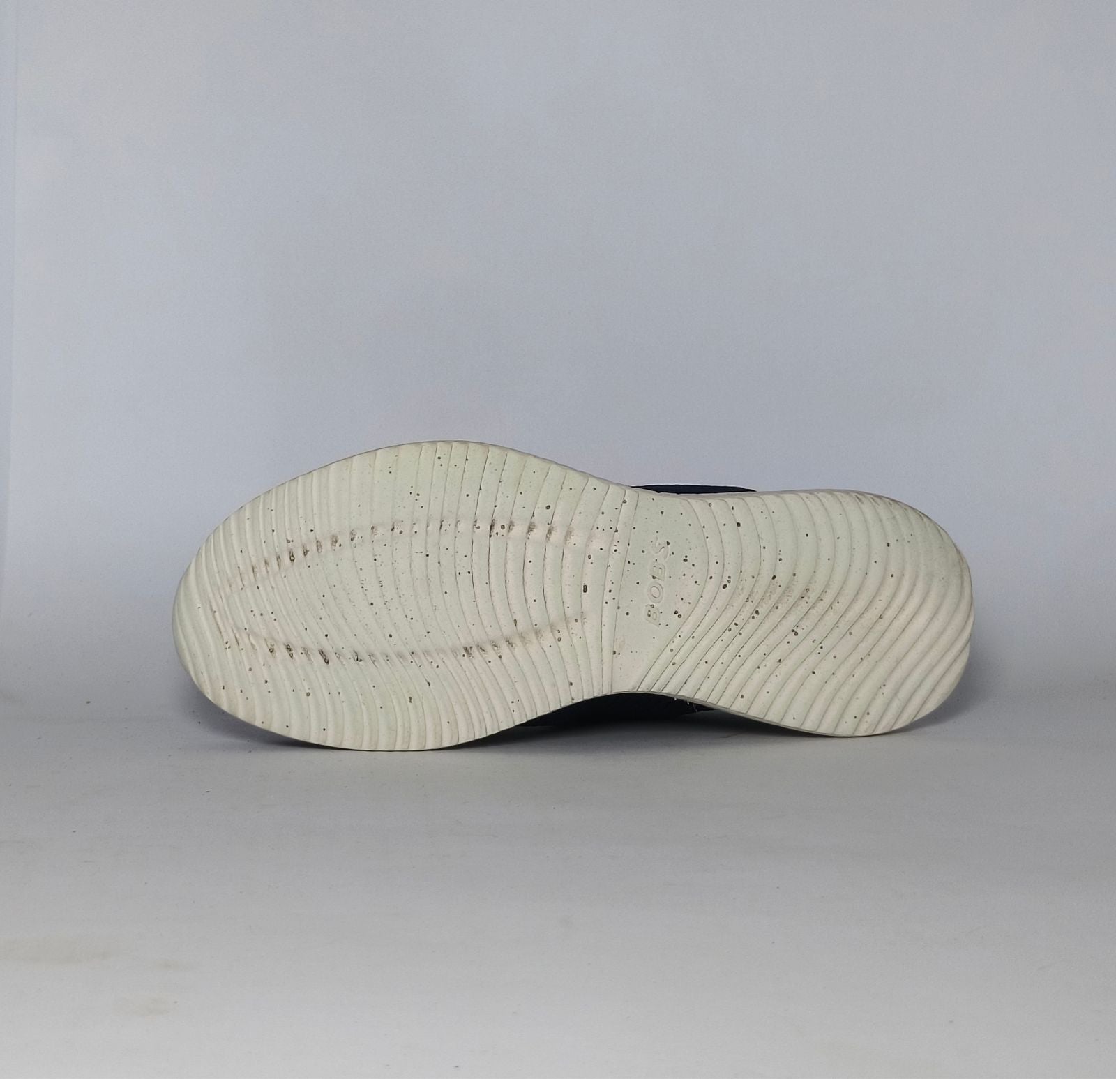 navy blue Skechers BOBS Squad sneaker featuring a white midsole and a textured knit upper.