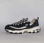 navy blue and silver Skechers D'Lites sneaker featuring a thick white midsole and a rugged black traction outsole.