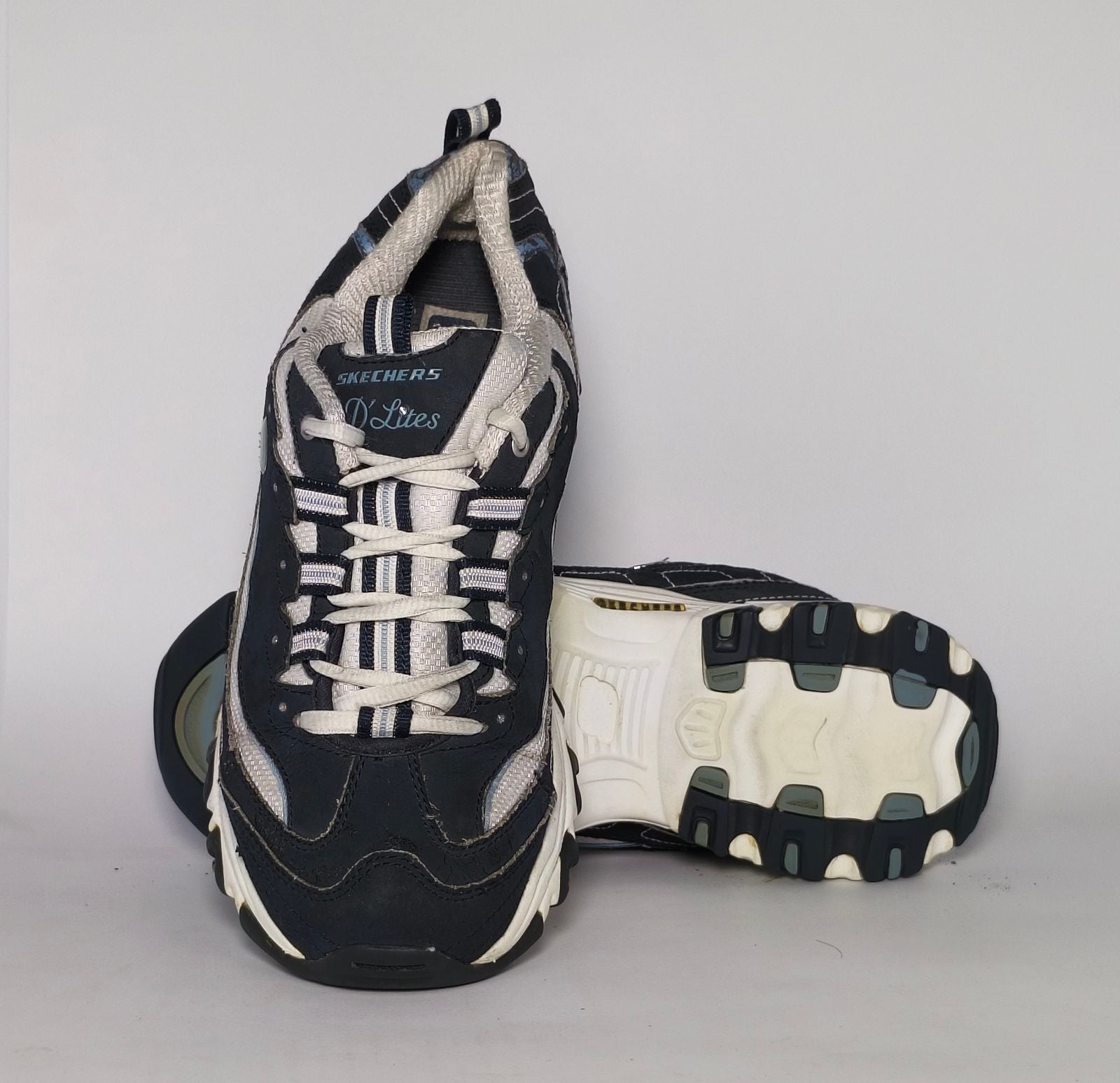 navy blue and silver Skechers D'Lites sneaker featuring a thick white midsole and a rugged black traction outsole.