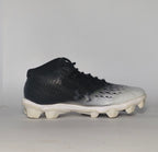 black and silver gradient Under Armour football cleat featuring a textured upper and a white molded cleat outsole.