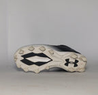 black and silver gradient Under Armour football cleat featuring a textured upper and a white molded cleat outsole.