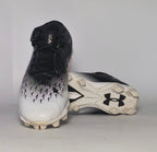 black and silver gradient Under Armour football cleat featuring a textured upper and a white molded cleat outsole.