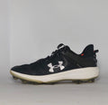 black Under Armour Harper baseball cleat featuring a white logo, white midsole, and a specialized cleated outsole for field traction.