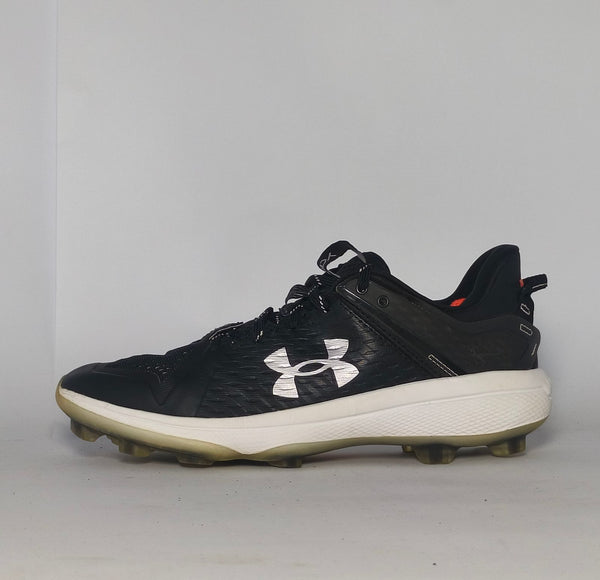 black Under Armour Harper baseball cleat featuring a white logo, white midsole, and a specialized cleated outsole for field traction.