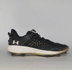 black Under Armour Harper baseball cleat featuring a white logo, white midsole, and a specialized cleated outsole for field traction.