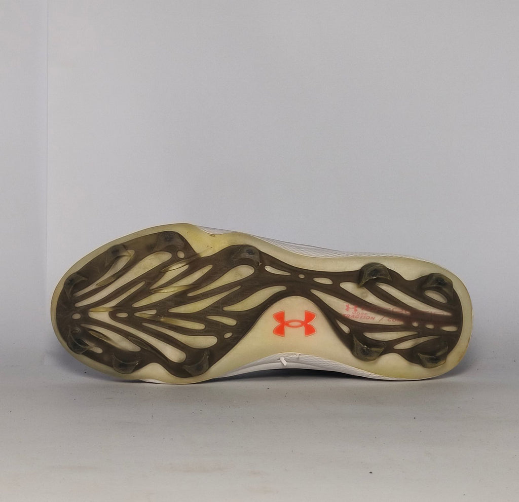 black Under Armour Harper baseball cleat featuring a white logo, white midsole, and a specialized cleated outsole for field traction.
